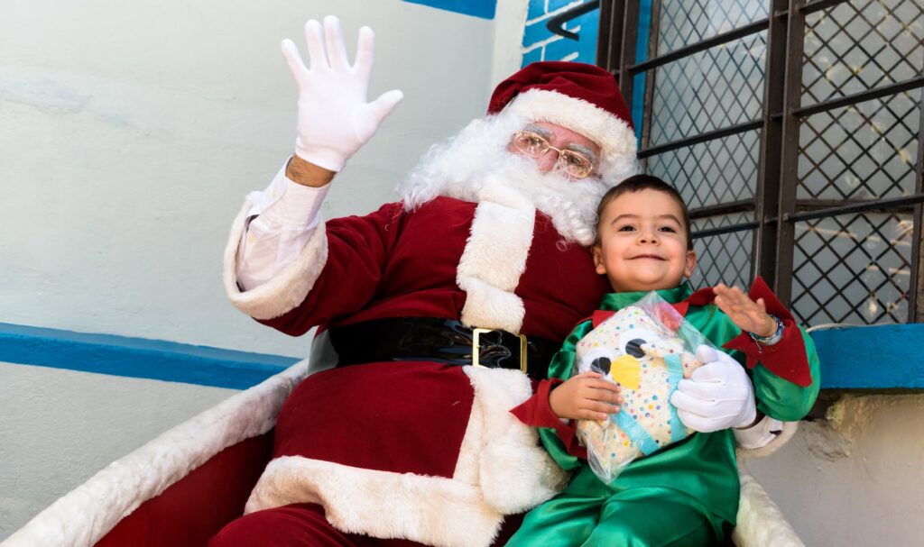 Smiling little boy sitting with Santa clause