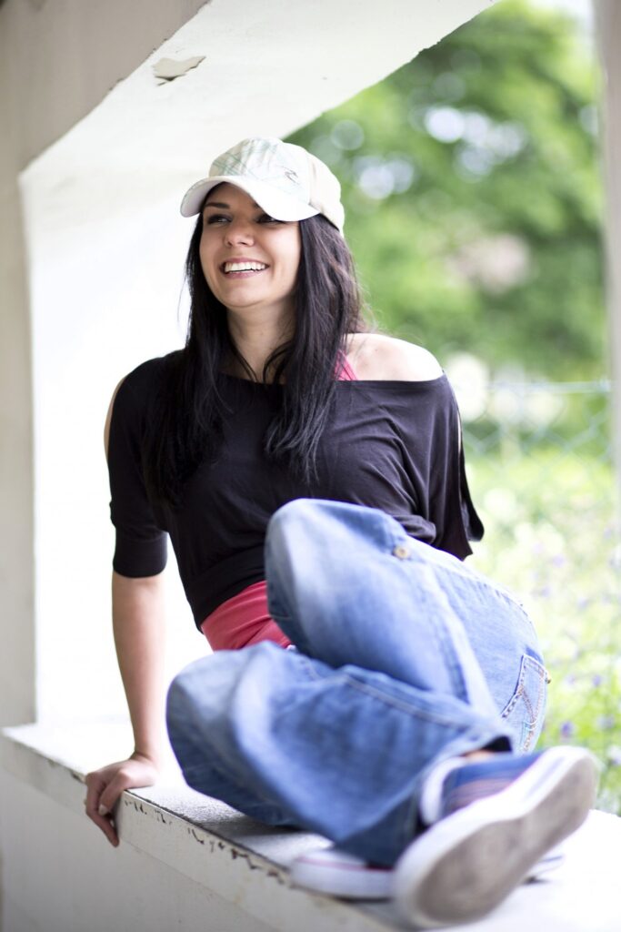 Teenage girl sitting on a ledge smiling